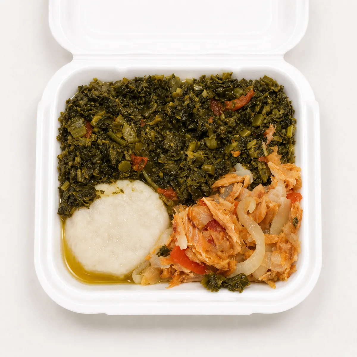 Saltfish and callaloo with a white traditional starch in a takeout container
