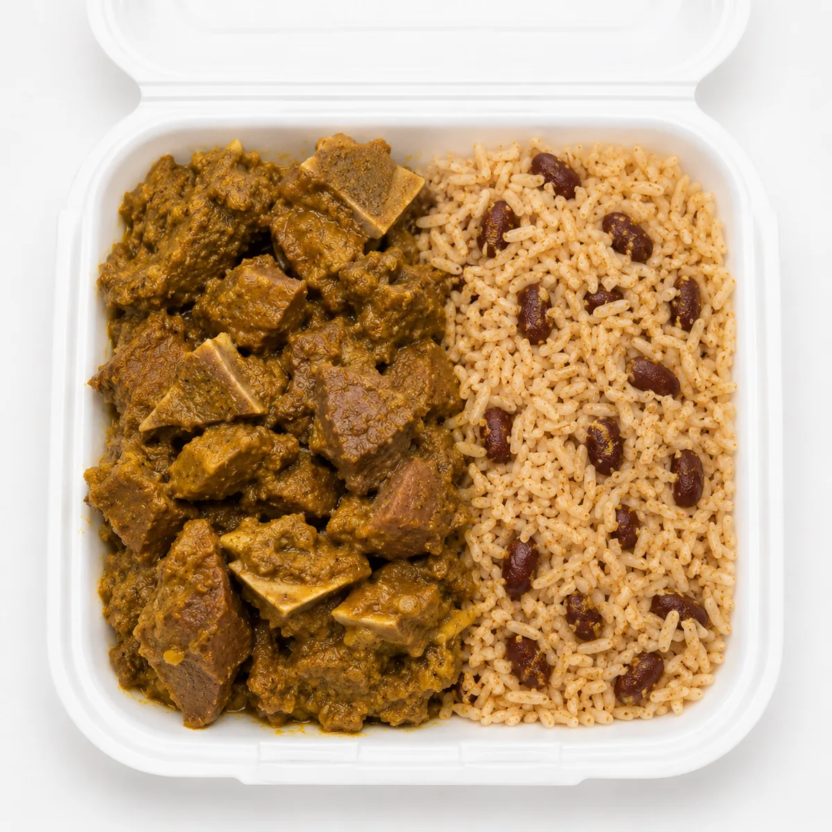 Curry goat meal in a white takeout container