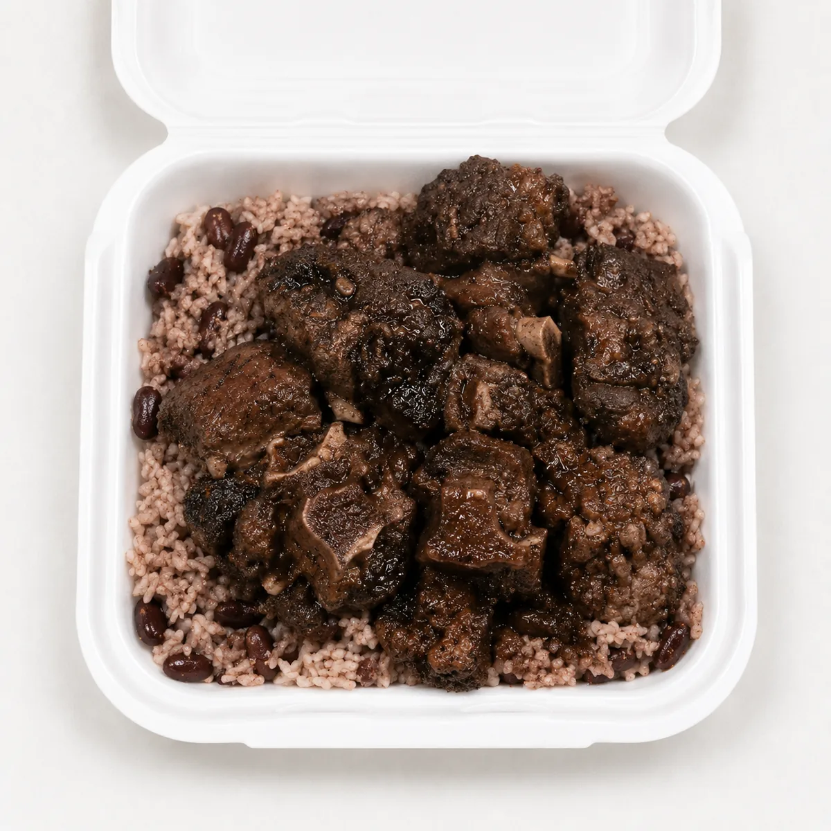 Oxtail with rice and peas in a white takeout container
