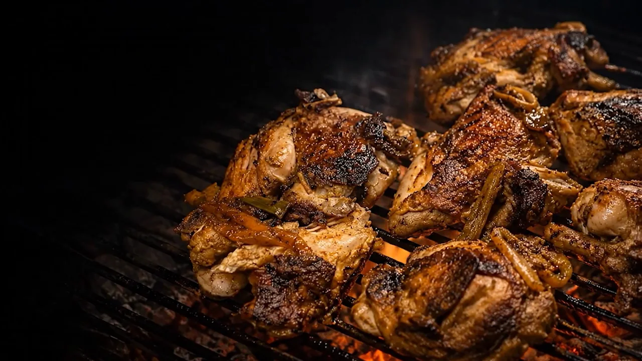 Jerk chicken over glowing fire and smoke